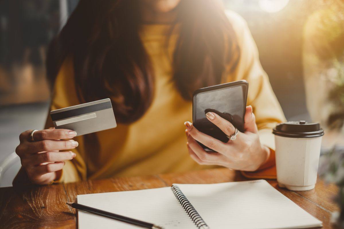 Ragazza con Bancomat e telefonino