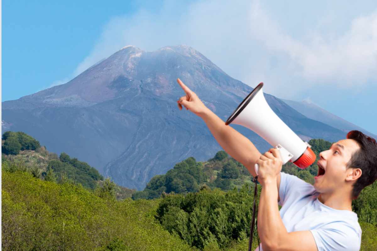 Persona con megafono che indica l'Etna