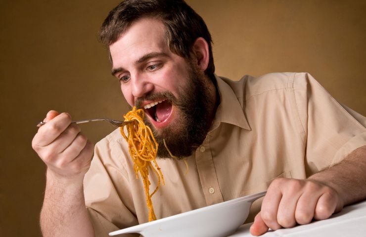 Uomo consuma piatto di pasta